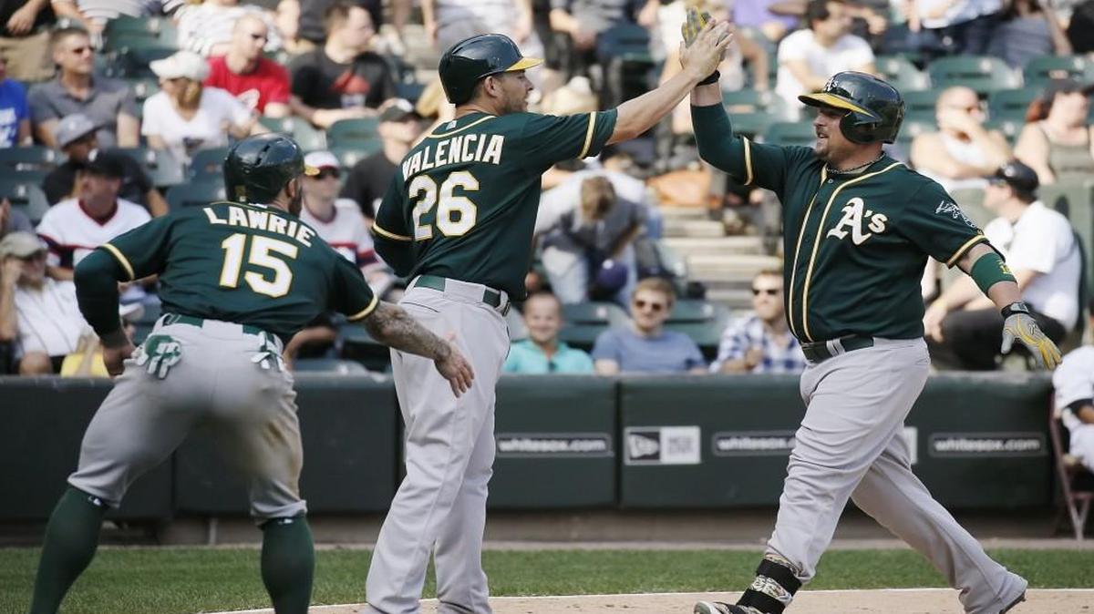 Oakland Athletics designated hitter Billy Butler (right) celebrated with Danny Valencia (middle) and Brett Lawrie, who scored on this three-run home run during a game last September.