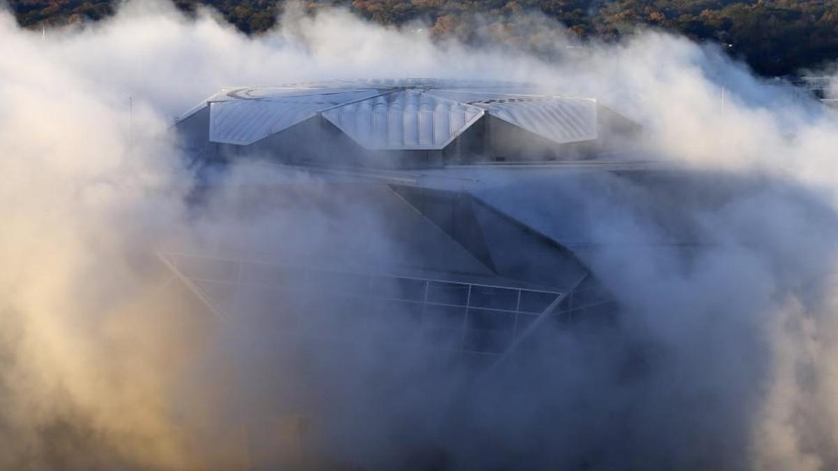 A dust cloud engulfs the Mercedes-Benz Stadium following the implosion of the Georgia Dome, which was next door to the stadium.