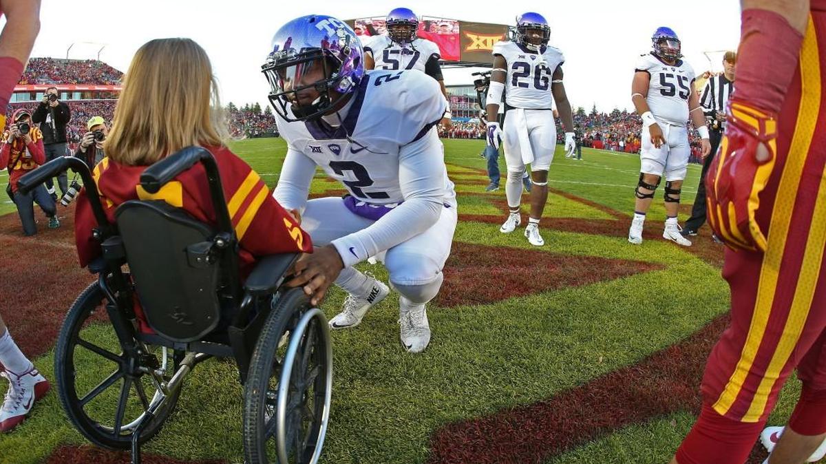 In this photo taken Saturday, Oct. 17, 2015, TCU quarterback Trevone Boykin spoke with Abby Faber, an Iowa State kid captain, before the coin toss for the game in Ames.