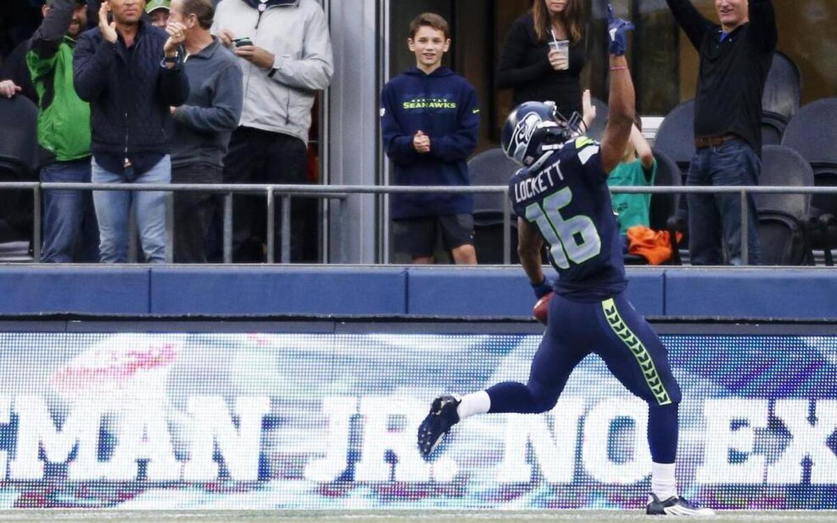 
Seattle Seahawks returner Tyler Lockett celebrated with fans after he returned a kickoff 103 yards for a touchdown against the Denver Broncos during Friday’s preseason game.
