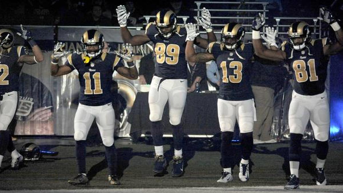 
Members of the St. Louis Rams raise their arms in awareness of the events in Ferguson, Mo., as they walked onto the field during introductions before Sunday’s game against the Oakland Raiders. 
