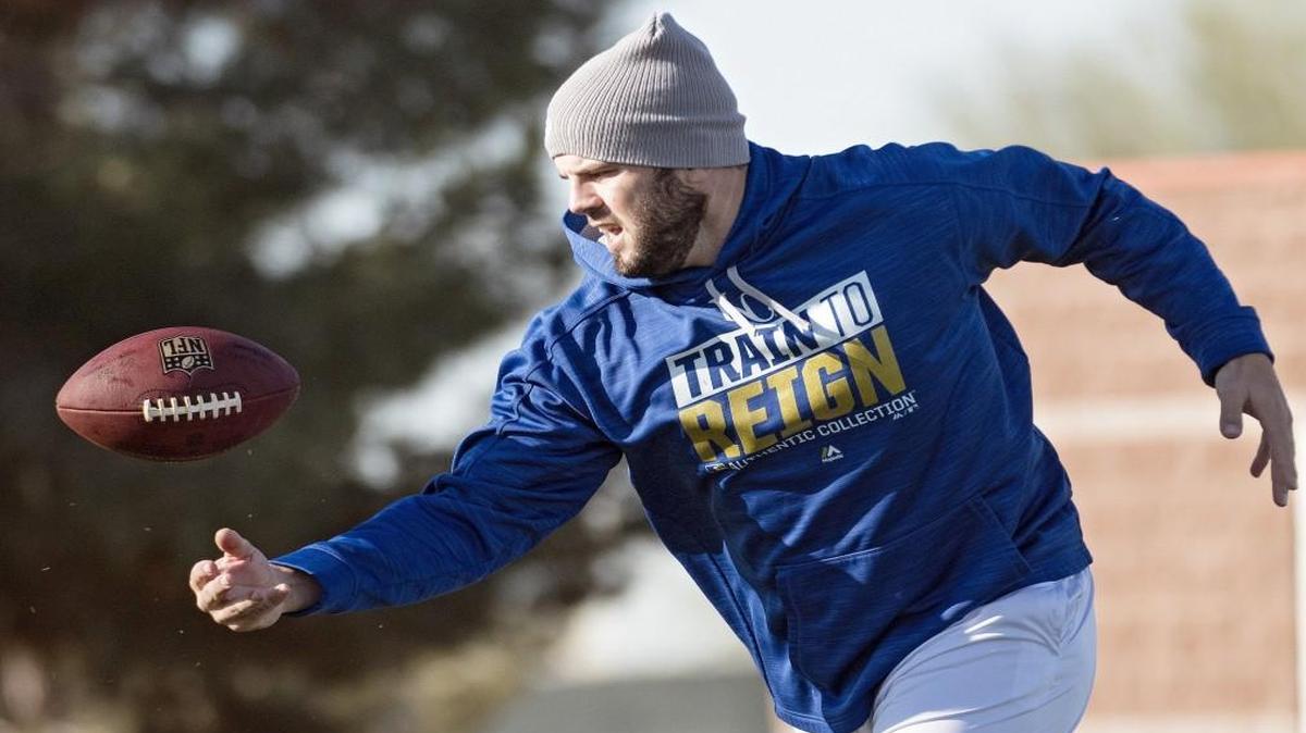 Kansas City Royals third baseman Mike Moustakas chased down a football pass while working on his agility drills a spring-training workout in Surprise, Ariz.