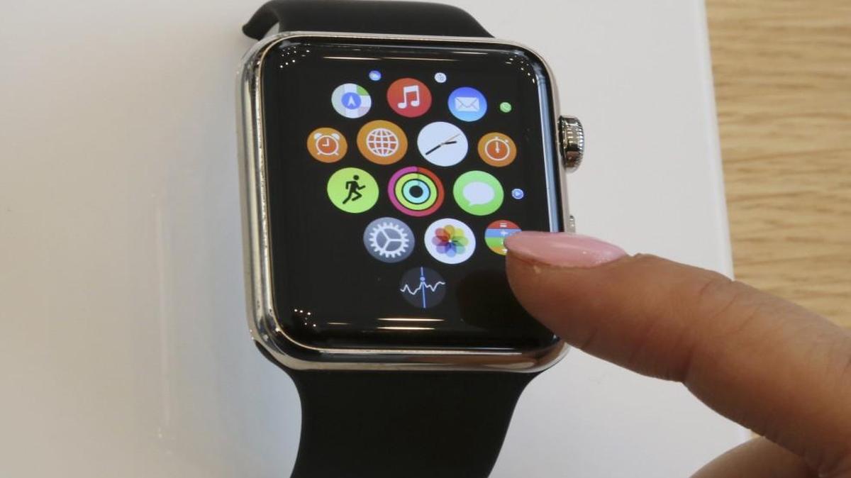 In this April 10, 2015, file photo, a customer demonstrates the Apple Watch at an Apple Store in Tokyo.