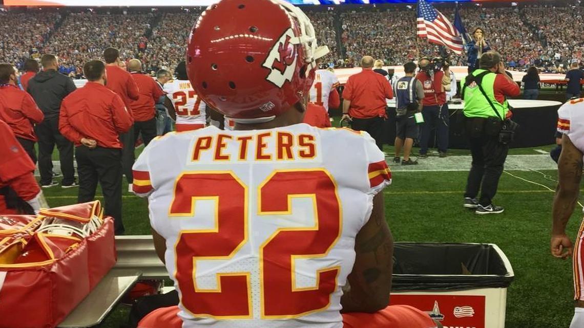 Marcus Peters sat on a trainer’s table while the national anthem was played Thursday night.