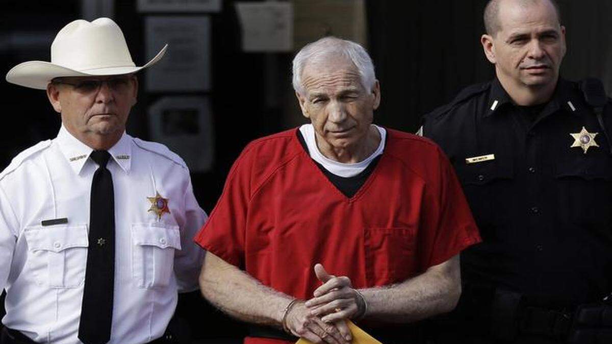 
In this Oct. 9, 2012 file photo, former Penn State University assistant football coach Jerry Sandusky (center) was taken from the Centre County Courthouse after being sentenced in Bellefonte, Pa. 
