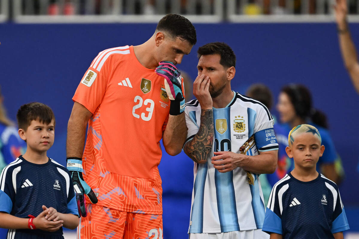 Argentina's goalkeeper Emiliano Martinez (left) chats with Lionel Messi ahead of the 2026 World Cup Group J football match between Argentina and Algeria at the Kansas City Stadium in Kansas City on June 16, 2026.