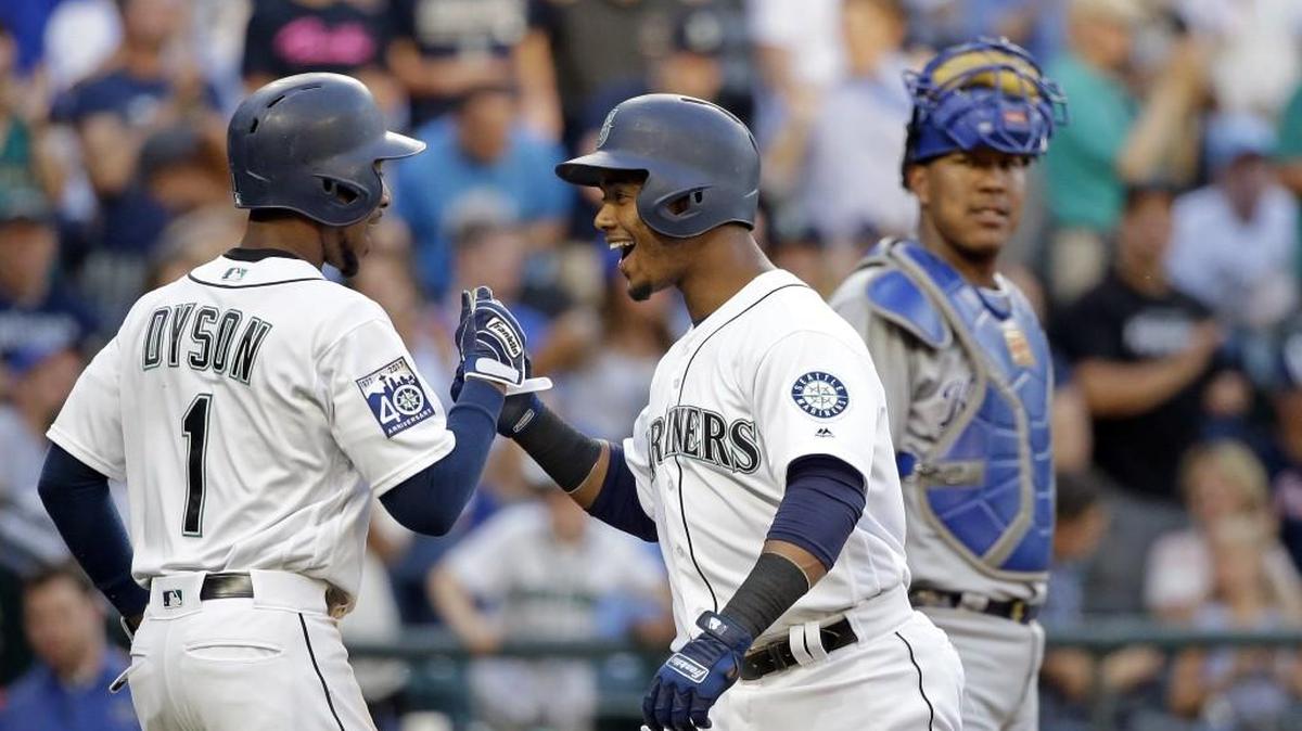 Seattle’s Jarrod Dyson (left) greeted teammate Jean Segura as Kansas City Royals catcher Salvador Perez watched after Segura’s two-run home run on Wednesday.