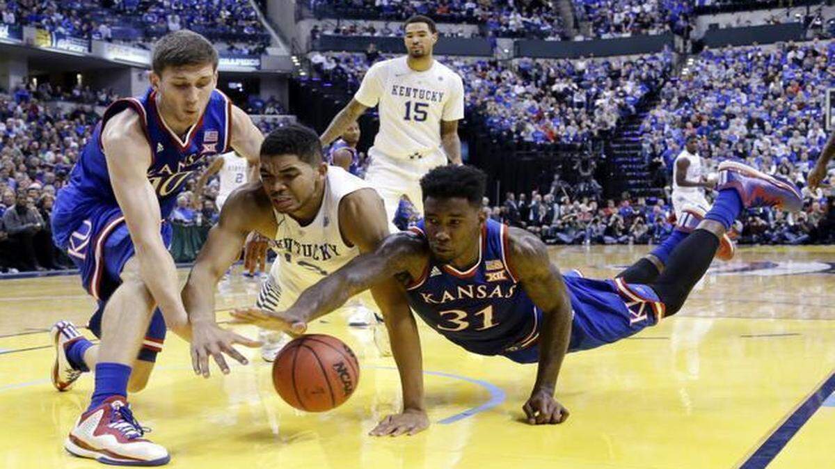 
Kentucky’s Karl-Anthony Towns (center) battled for a loose ball with Kansas’ Sviatoslav Mykhailiuk (left) and Jamari Traylor during a game on Nov. 18, 2014. 
