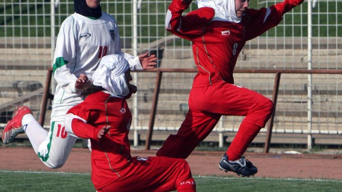 
In this 2006 file photo, Berlin’s soccer team player, Valerie Assmann (right) fights for the ball in front of her unidentified teammate and Iranian women soccer team player, Niloufar Ardalan (left) during their friendly match at the Ararat stadium in Tehran, Iran. Iranian women’s soccer captain Ardalan reportedly will miss the Asian Cup tournament as her husband has confiscated her passport.
