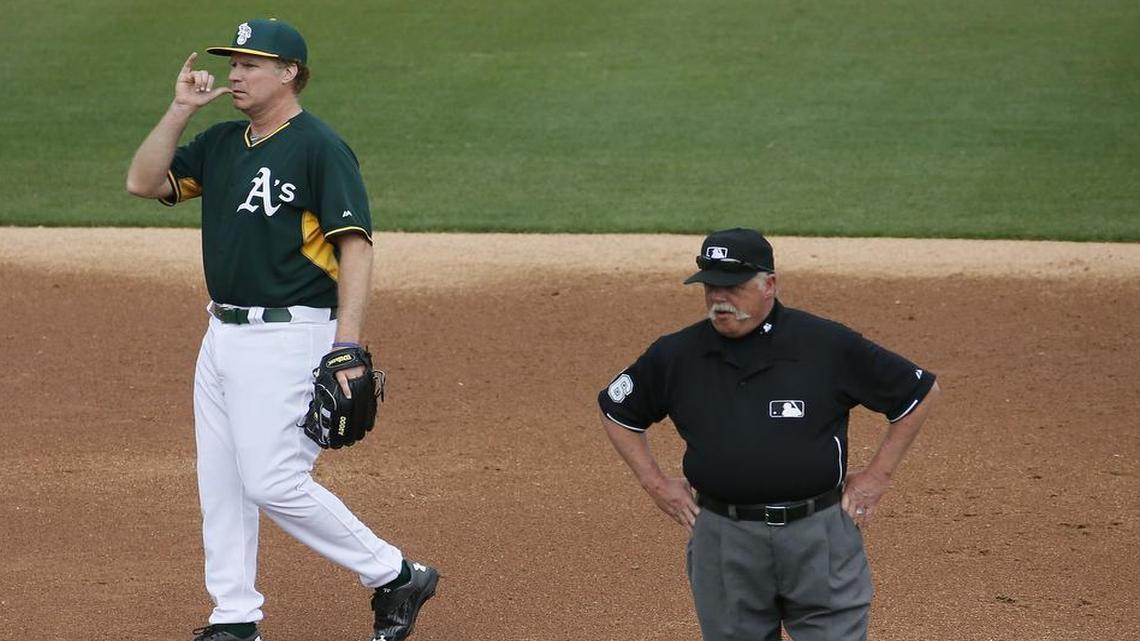 
Actor Will Ferrell made a drinking gesture, while playing shortstop for the Oakland A's, behind umpire Jim Joyce during the first inning of a spring training baseball game against the Seattle Mariners on March 12, 2015, in Mesa, Ariz. 
