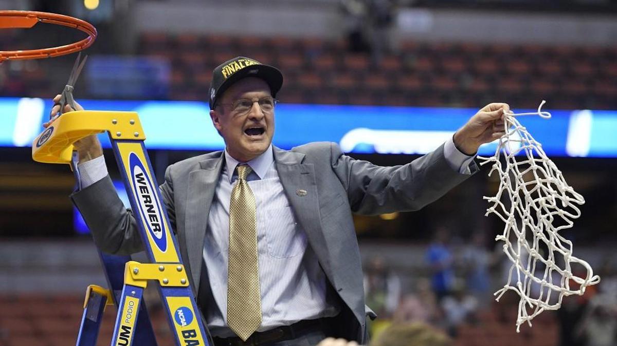 Oklahoma head coach Lon Kruger cuts down the net after their win against Oregon in the regional final. Does OU’s success this season trump Kansas’.