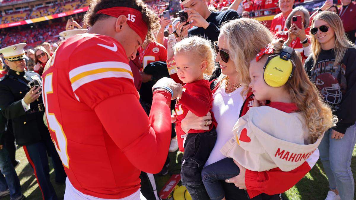 Patrick Mahomes of the Kansas City Chiefs fist bumps his son, Bronze, while his wife and daughter, Brittany and Sterling, watch prior to a game against the Denver Broncos at GEHA Field at Arrowhead Stadium on Nov. 10, 2024 in Kansas City, Missouri.