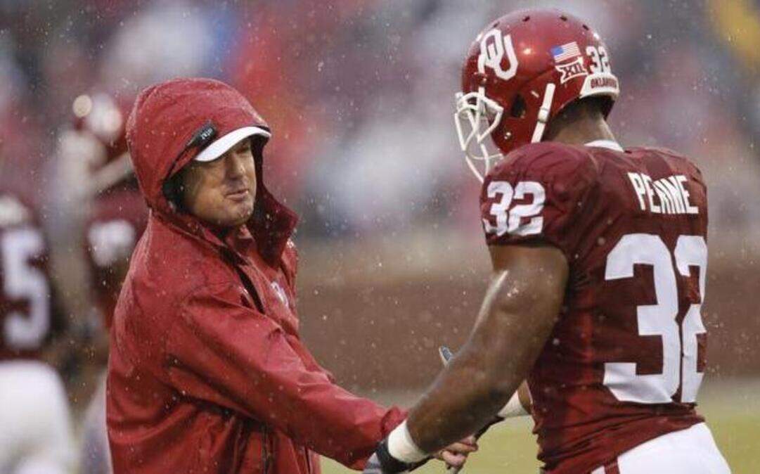 
Oklahoma head coach Bob Stoops congratulated Samaje Perine following a touchdown against Kansas in the first quarter on Saturday.
