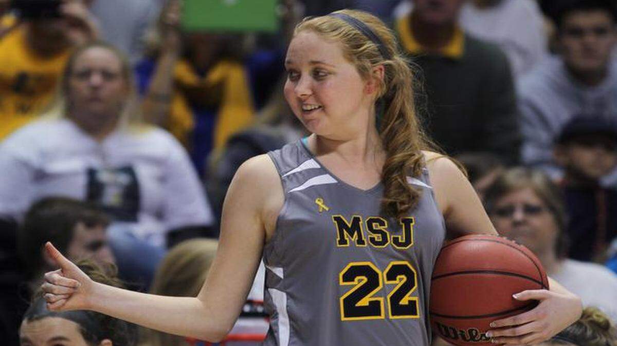 
Mount St. Joseph's Lauren Hill gives thumbs up as she holds the game ball during her first NCAA college basketball game against Hiram University.
