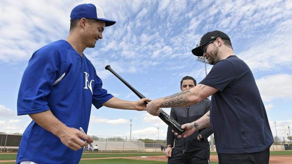 
Kansas City Royals pitcher Jeremy Guthrie autographed a bat for singer David Cook as guitarist Daniel Damico looked on after Cook and Damico took some batting practice with Guthrie on Sunday in Surprise, Ariz.
