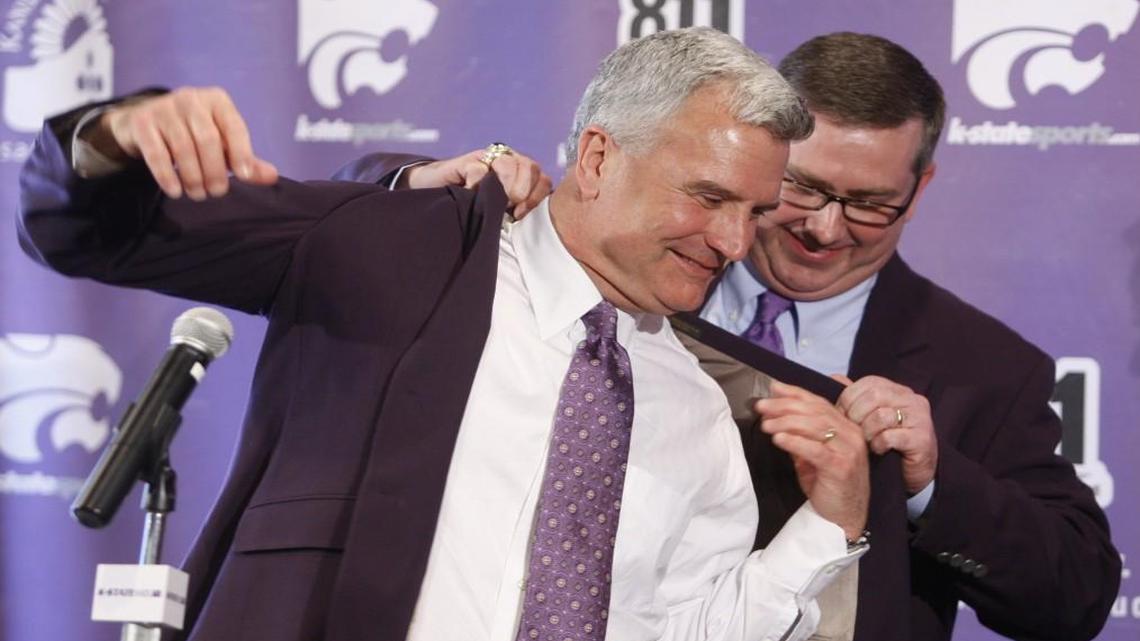 Kansas State University president Kirk Schulz helped head basketball coach Bruce Weber into a purple jacket after Weber was introduced as the Wildcats’ basketball coach in 2012.