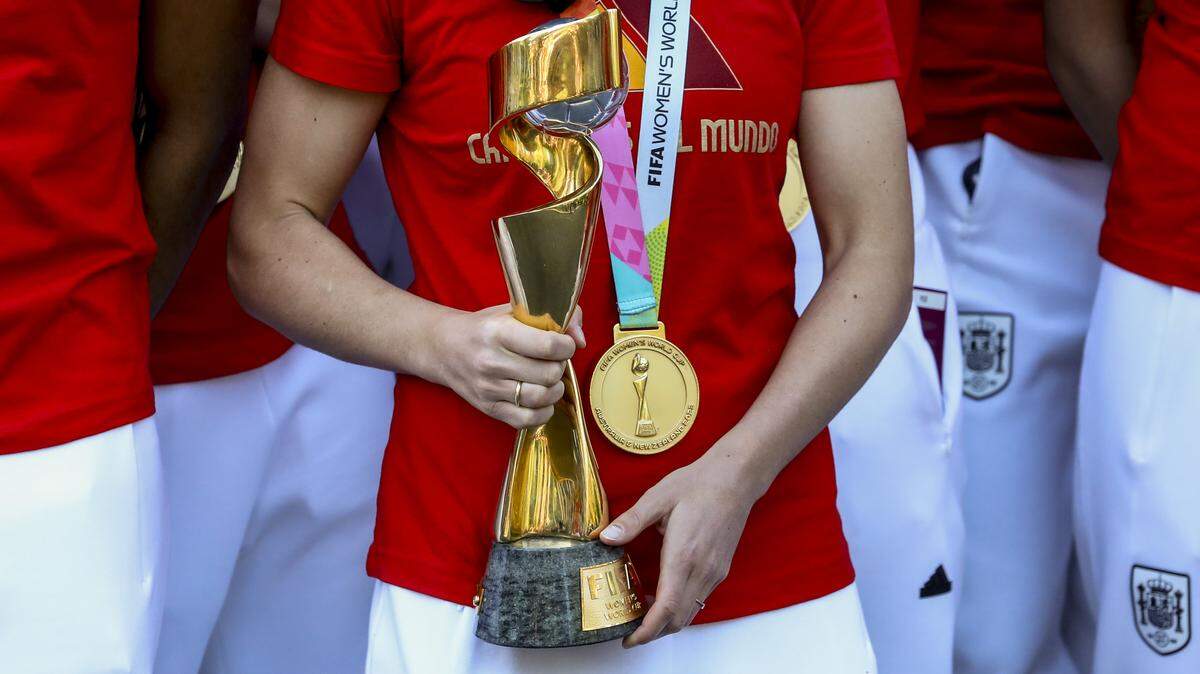 Spanish soccer player Ivana Andrés holds the Women's World Cup trophy.