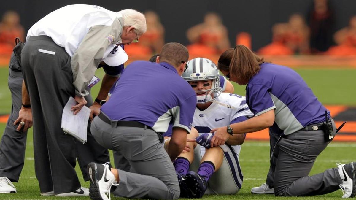
Kansas State head coach Bill Snyder (left) talked with quarterback Joe Hubener, while medical personnel examined him during the first quarter of Saturday’s game.
