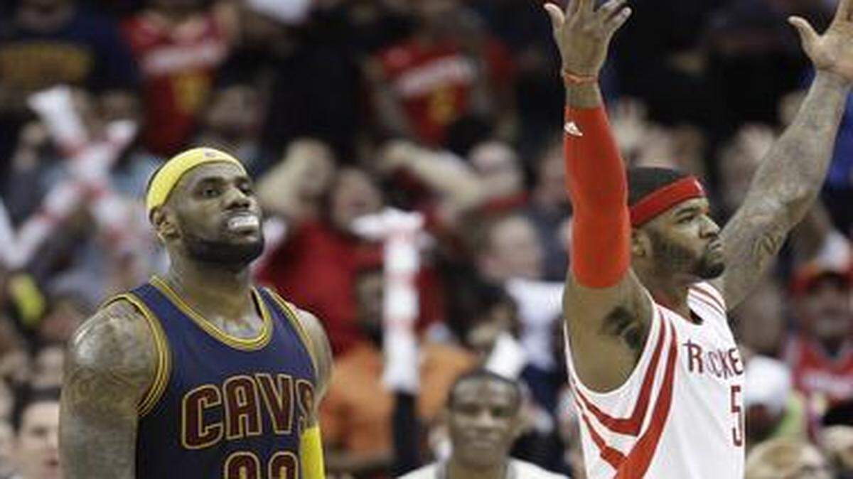 
Cleveland’s LeBron James (left) headed for the bench after missing two free throws as Houston’s Josh Smith celebrated in the final seconds of overtime on Sunday. The Rockets won 105-103.
