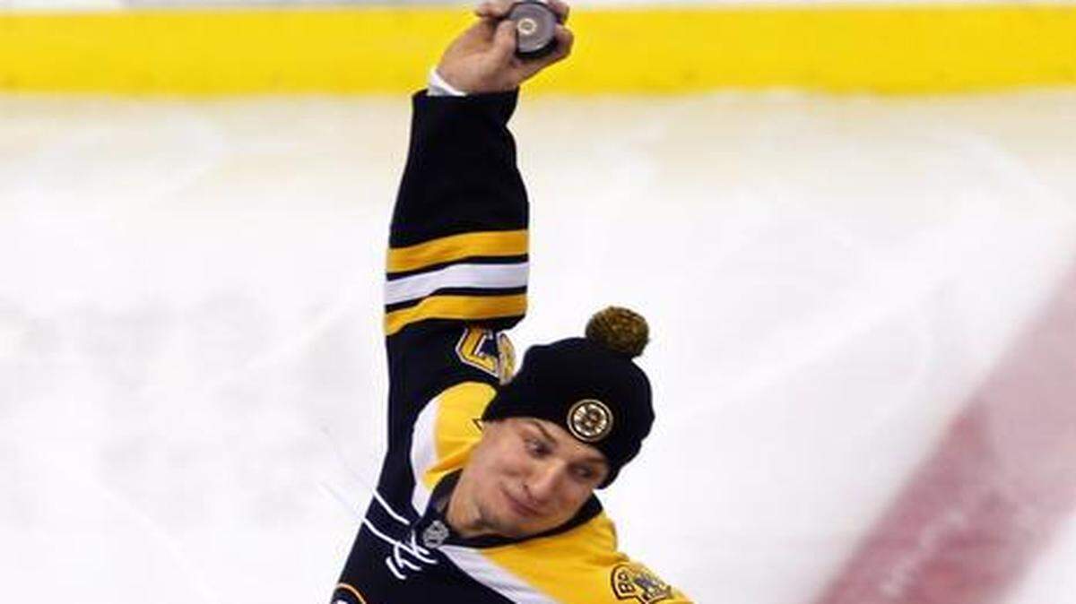 
New England Patriots tight end Rob Gronkowski spikes a hockey puck at center ice before an NHL hockey game between the Boston Bruins and the New York Islanders in Boston on Saturday.
