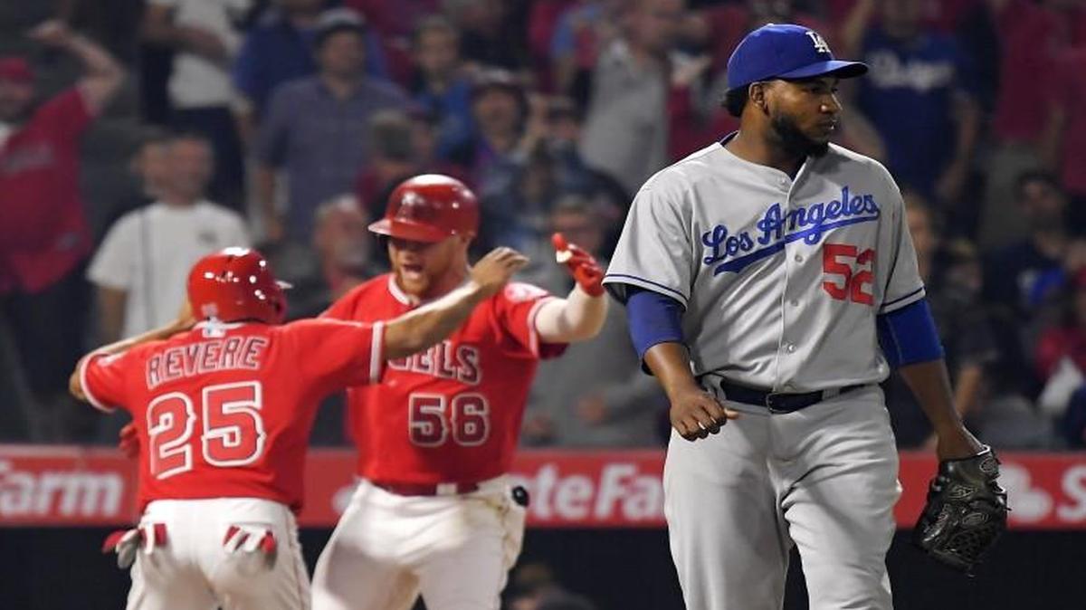Los Angeles Angels outfielder Ben Revere (left) celebrated along with Kole Calhoun after Revere scored the game-winning run as Dodgers relief pitcher Pedro Baez (right) walked off the field on Wednesday.
