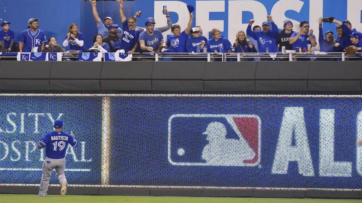 Fans celebrate after catching a home run ball hit by Kansas City Royals third baseman Mike Moustakas in the second inning of ALCS Game 6 at Kauffman Stadium. The Toronto Blue Jays challenged the call thinking that there may have been fan interference on the play.