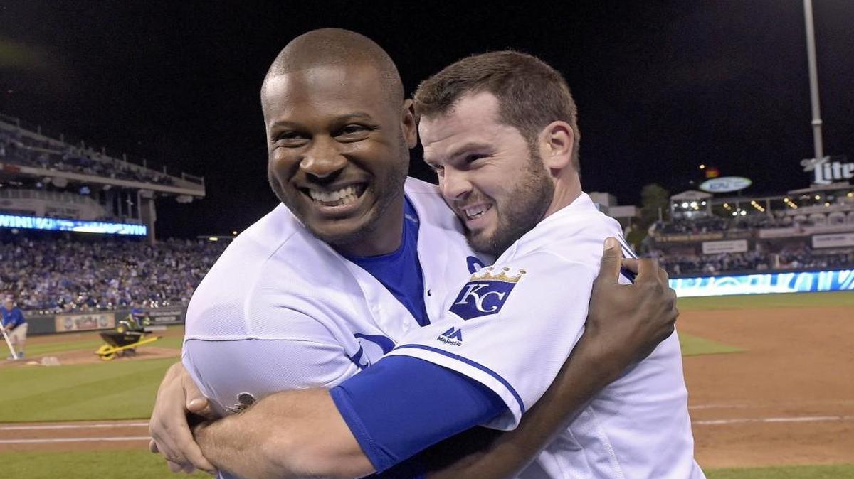 The Royals’ Lorenzo Cain and Mike Moustakas hugged as they were prepare to be doused with water from Salvador Perez after the 7-6 win over the Washington Nationals on Tuesday.