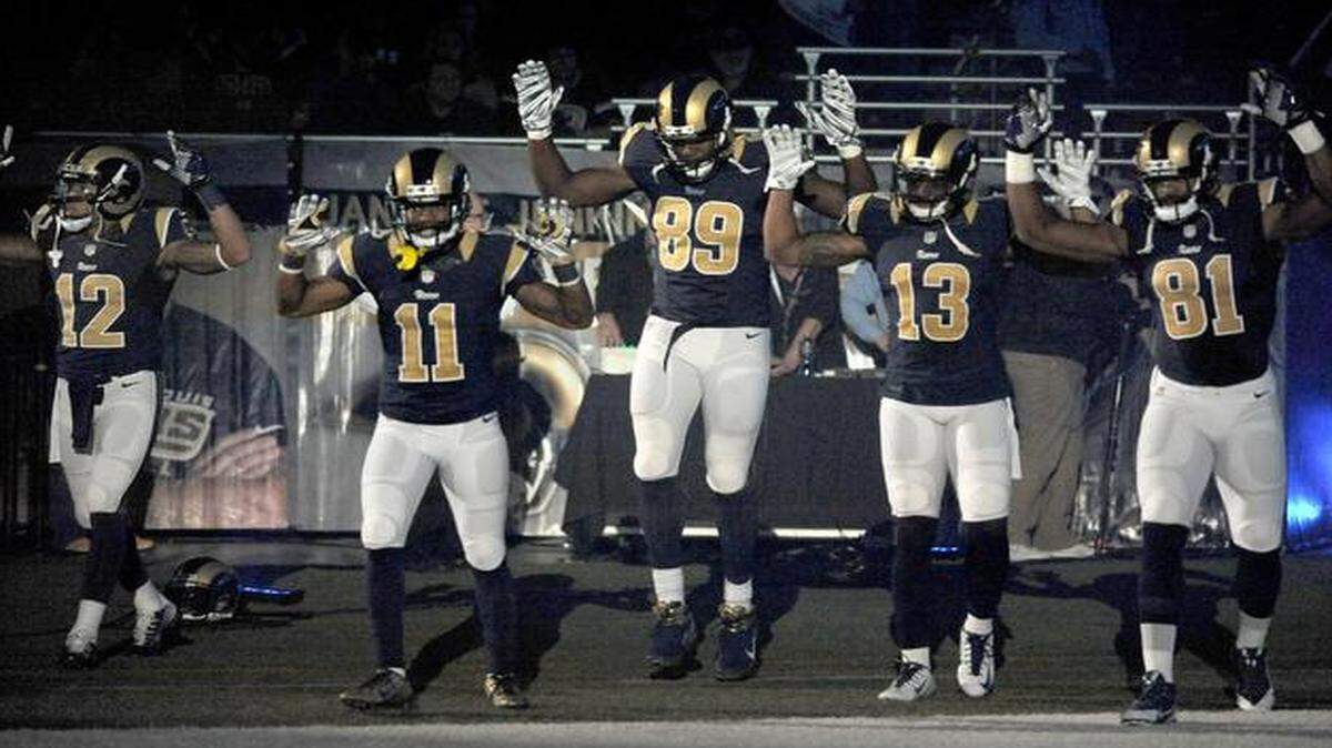 
Members of the St. Louis Rams raise their arms in awareness of the events in Ferguson, Mo., as they walk onto the field during introductions before Sunday’s game.

