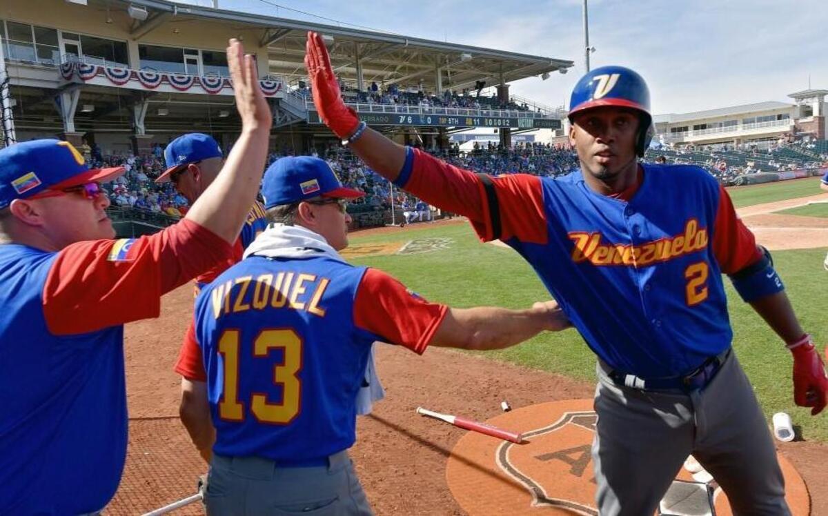 Venezuela’s Alcides Escobar was congratulated after scoring following his RBI triple during Wednesday’s spring-training game against the Royals in Surprise, Ariz. Escobar and Royals teammate Salvador Perez wore armbands in memory of Yordano Ventura.