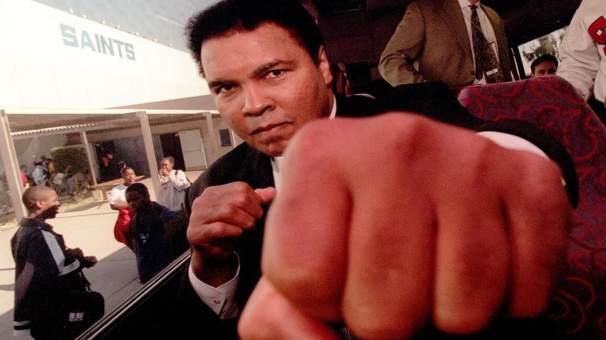 Muhammad Ali threw a playful punch toward a photographer while visiting Locke High School in Los Angeles on Dec. 4, 1996.