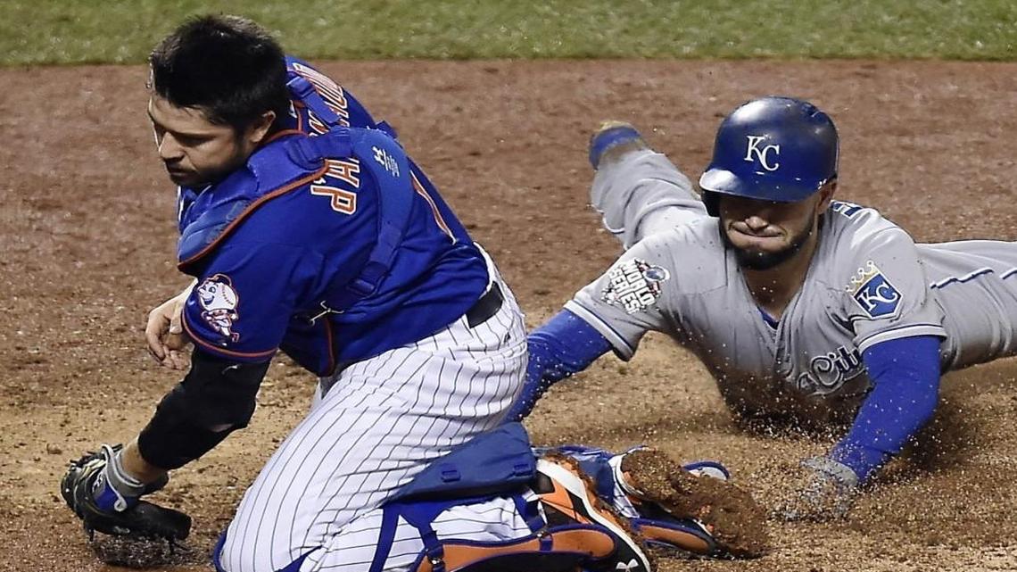 New York Mets catcher Travis d’Arnaud was pulled off home plate by a wide throw so he missed a chance to tag Kansas City Royals first baseman Eric Hosmer who scored in the ninth inning during Game 5 of last year’s World Series.