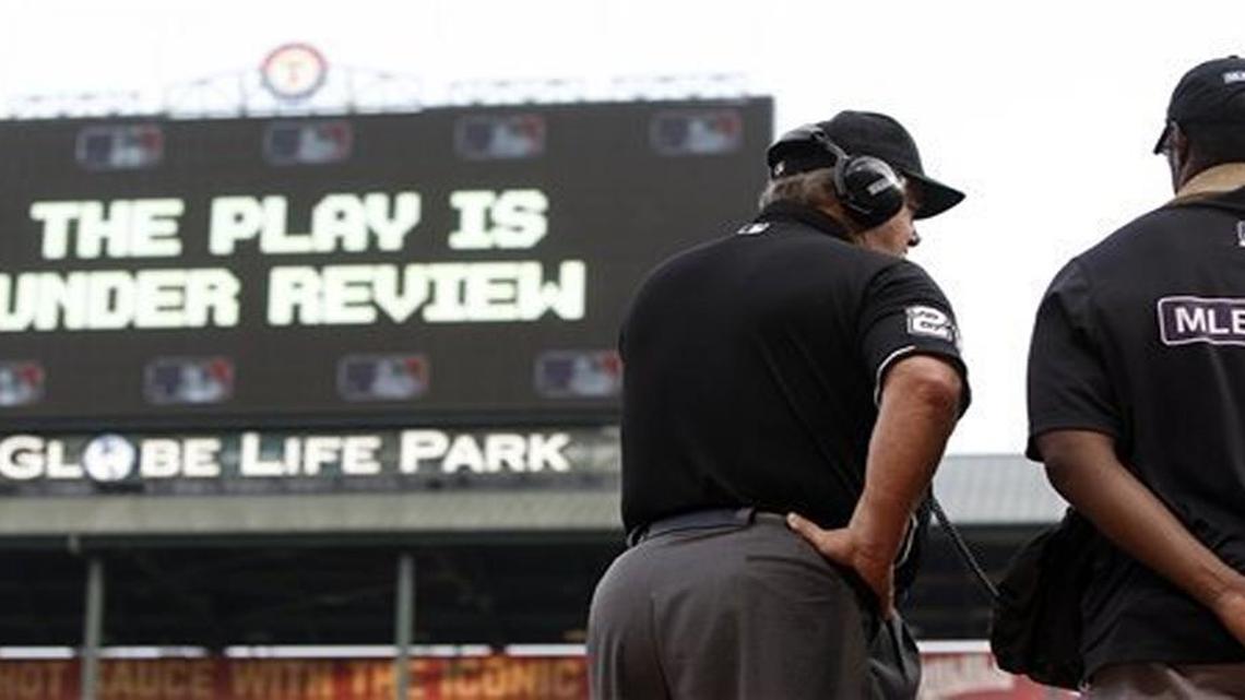 This May 16, 2015 file photo shows umpire Joe West connecting with Major League Baseball’s review command center in New York.