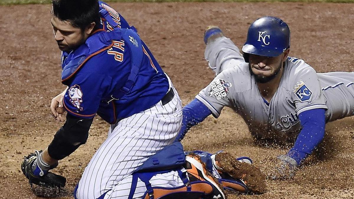 New York Mets catcher Travis d'Arnaud was pulled off home plate by a wide throw so he missed a chance to tag Kansas City Royals first baseman Eric Hosmer who scored in the ninth inning during game five of the World Series on Sunday, November 1, 2015 at Citi Field in New York.