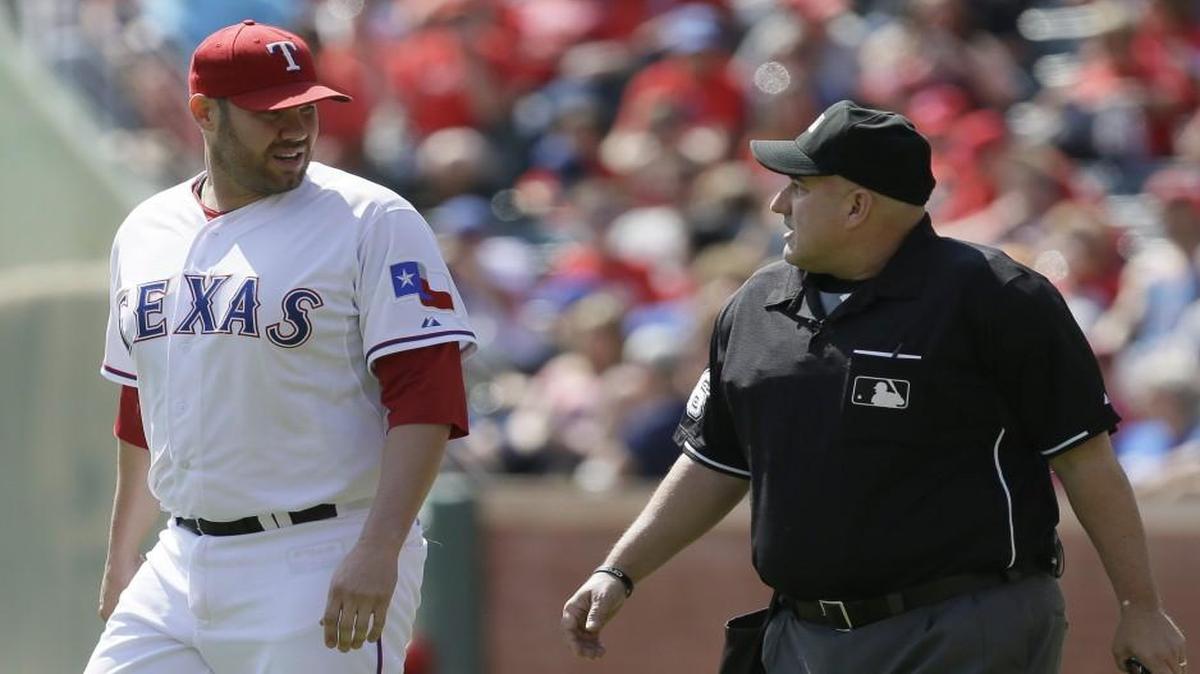 
Texas Rangers starting pitcher Colby Lewis (left) discussed a call with home plate umpire Eric Cooper during Saturday’s game.
