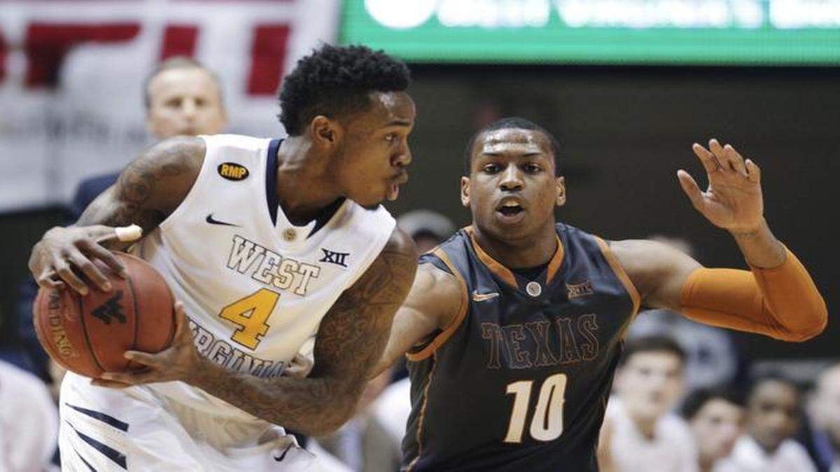 
West Virginia guard Daxter Miles Jr. (left) looked to make a pass as Texas forward Jonathan Holmes defended during a game last month.
