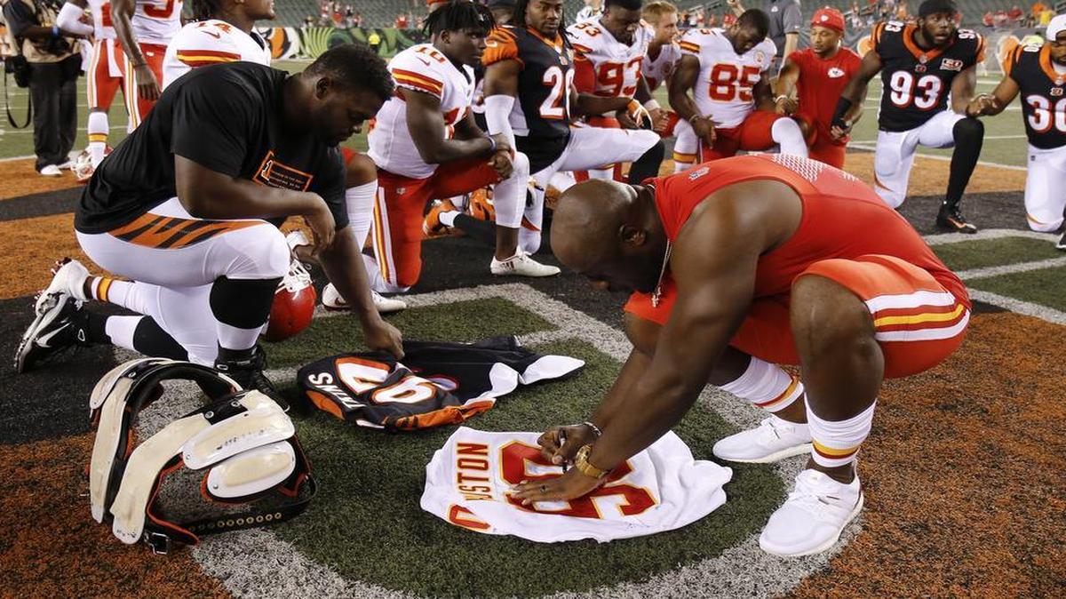 Kansas City Chiefs outside linebacker Justin Houston, right, and Cincinnati Bengals defensive tackle Geno Atkins, left, sign their jerseys before exchanging them following a preseason football game, Saturday, Aug. 19, 2017, in Cincinnati. The Chiefs won 30-12.