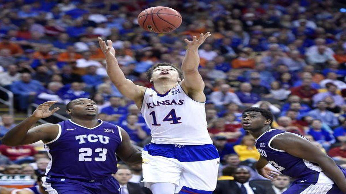 
KU’s Brannen Greene (middle) lost control of the ball while driving between TCU’s Devonta Abron (23) and Chris Washburn during the first half Thursday. When he remained behind the three-point arc, Greene missed all three of his attempts.

