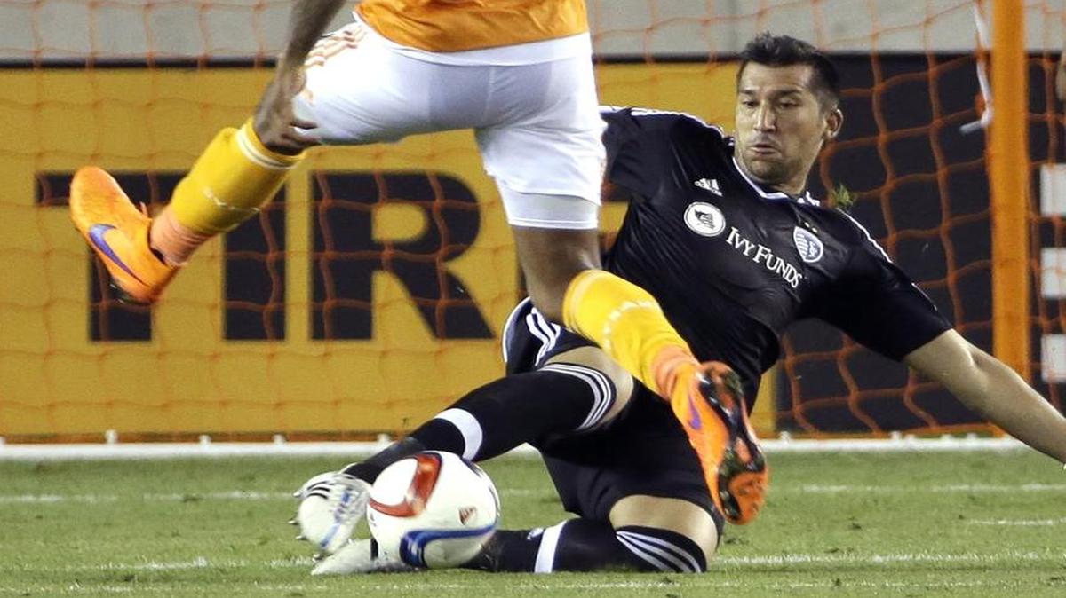 
Sporting Kansas City goalkeeper Luis Marin, right, kicks the ball away from Houston Dynamo's Giles Barnes (10) during the first half of an MLS soccer game Saturday, April 25, 2015, in Houston. 
