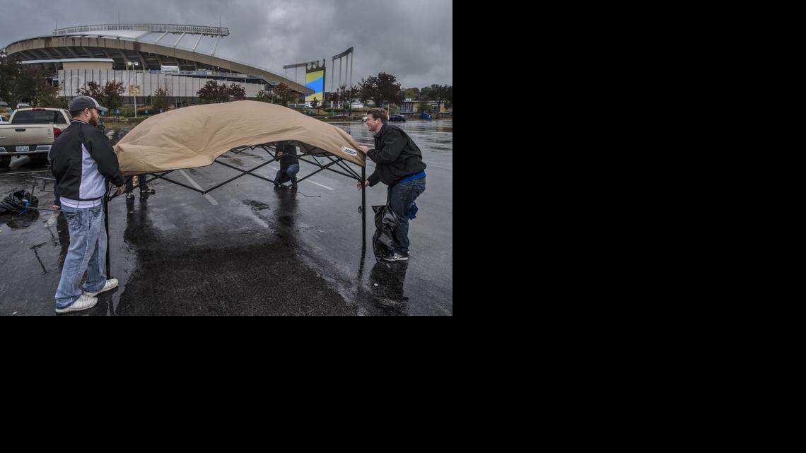 
Vincent Vigliaturo (left), of Blue Springs, helps Nick Hinrichs, of Kansas City, put his canopy away on Monday, Oct. 13, at Kauffman Stadium in Kansas City. The MLB has postponed game three of the American League Championship Series because of heavy rain. The third game of the series will be played Tuesday at Kauffman at 7:07 p.m.
