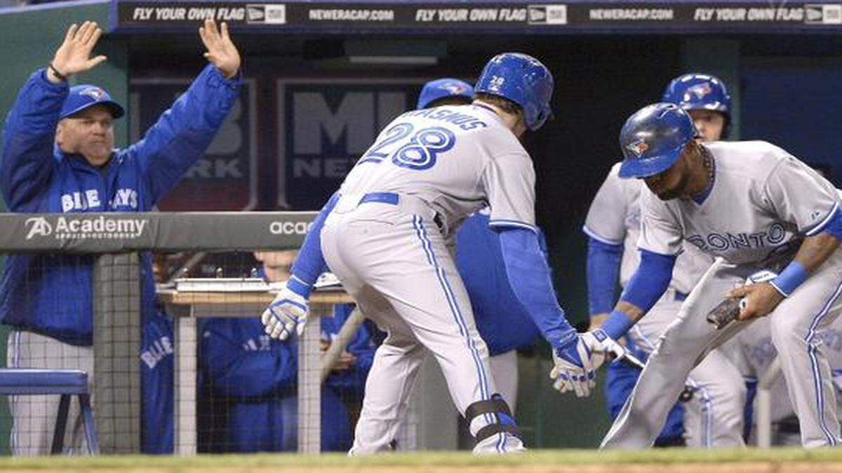 
The Blue Jays' Colby Rasmus (28) celebrates his solo home run with teammate Jose Reyes (7), as hitting coach Kevin Seitzer cheers during their May 1 game against the Royals at Kauffman Stadium.
