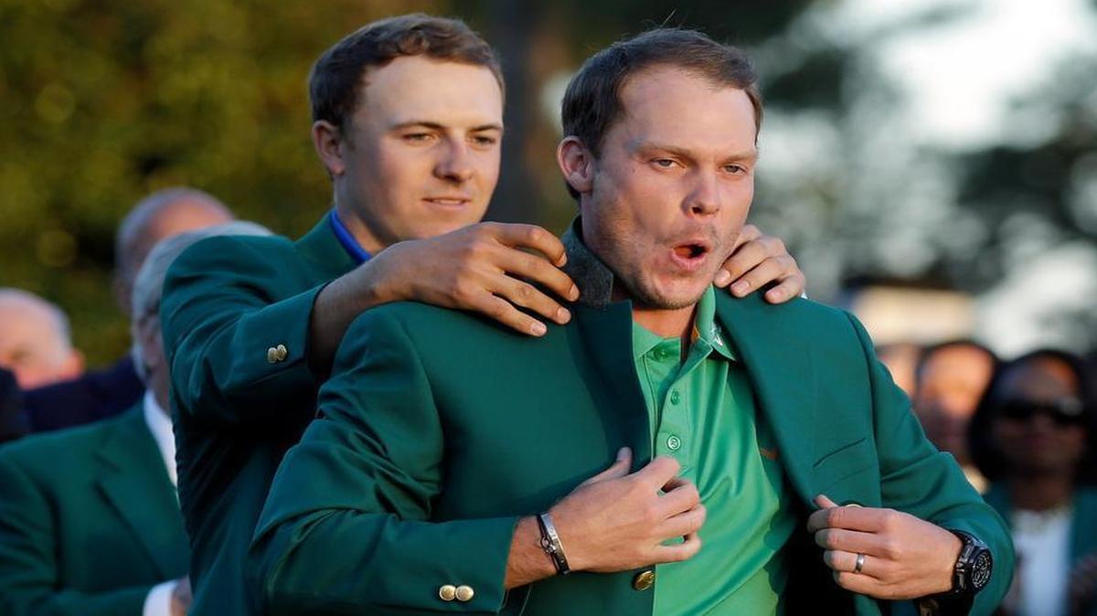 Defending Masters champion Jordan Spieth (left) helped this year’s winner, Danny Willett, put on his green jacket Sunday.