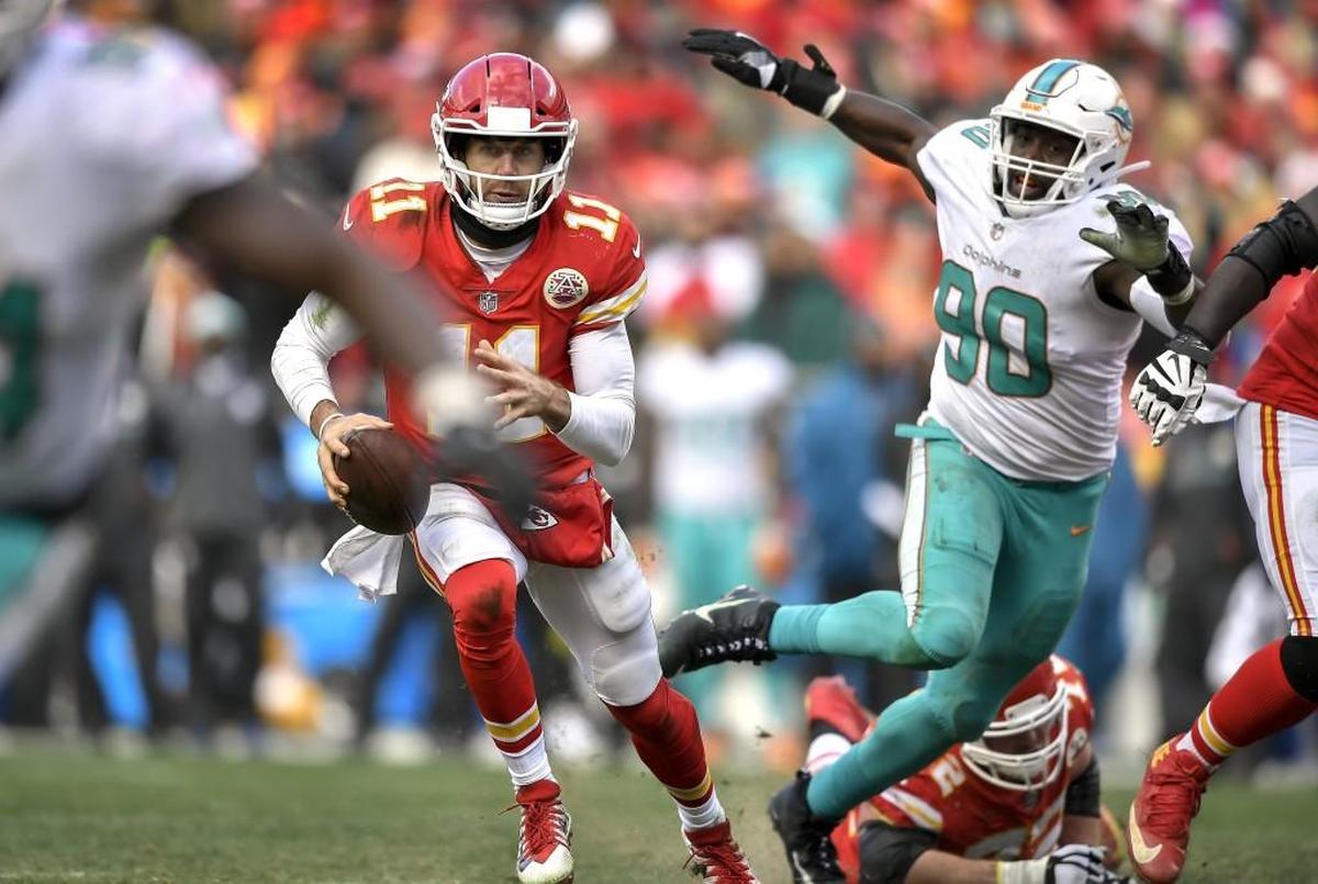 Chiefs quarterback Alex Smith (No. 11) eludes the pass rush of Dolphins defensive end Charles Harris during a December game at Arrowhead.