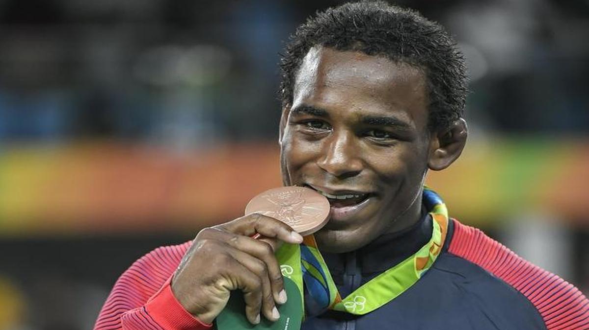 Missouri wrestler J’den Cox bit into his bronze medal, per Olympic tradition for photographs, on Saturday at Carioca Arena 2 in Rio de Janeiro.