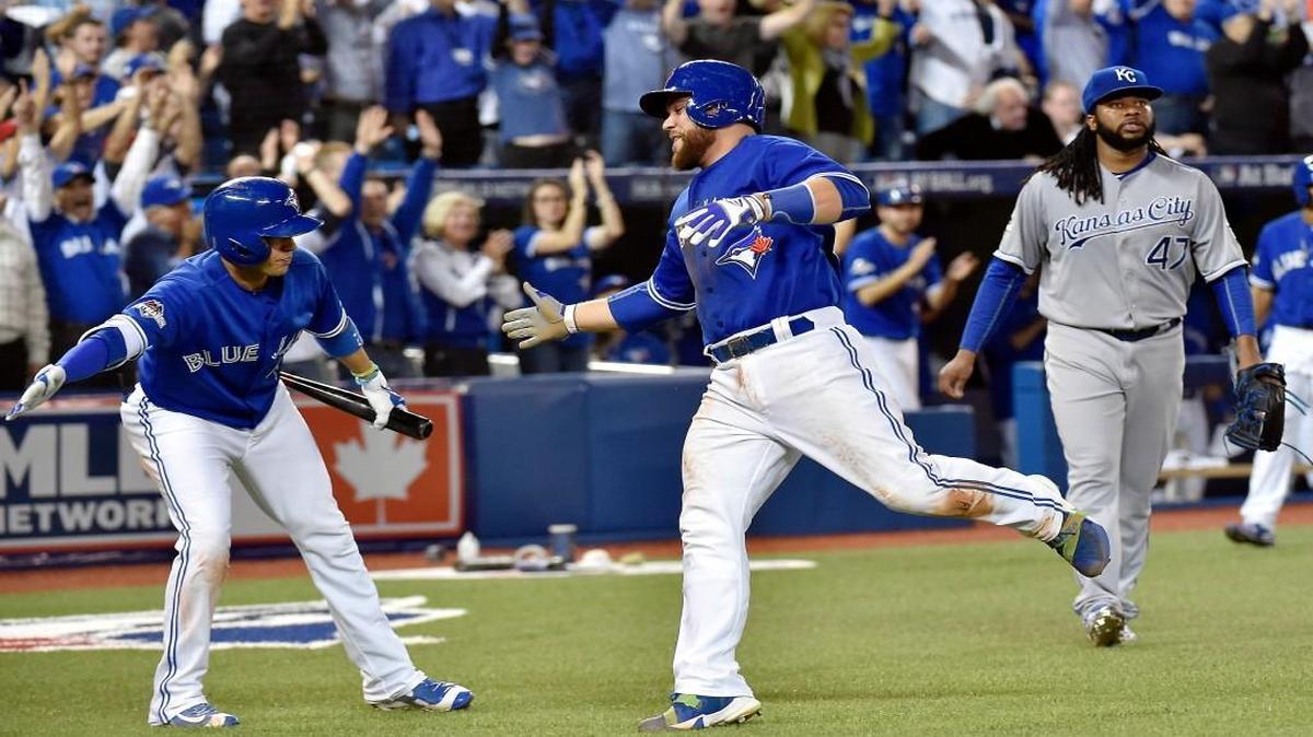 
Ryan Goins (left) greeted Blue Jays teammate Russell Martin after Martin scored on a double Kevin Pillar in the third inning against the Royals in Game 3 of the American League Championship Series on Monday at Rogers Centre in Toronto. The Blue Jays won 11-8. Kansas City now leads the best-of-seven series two games to one.
