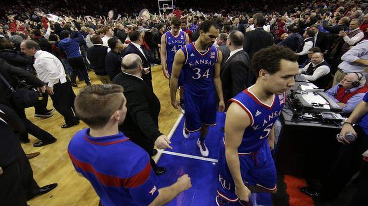 
Kansas' Evan Manning (5) Perry Ellis (34) and Hunter Mickelson (42) walk off the court after losing an NCAA college basketball game to Temple, 77-52, Monday, Dec. 22, 2014, in Philadelphia.
