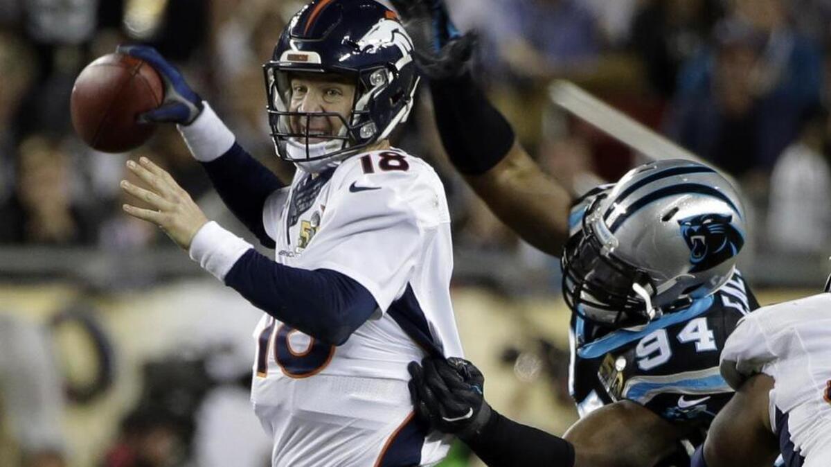 Denver quarterback Peyton Manning (right) lost the ball as he was hit by Carolina’s Kony Ealy (94) during the second half of the Super Bowl on Sunday in Santa Clara, Calif.