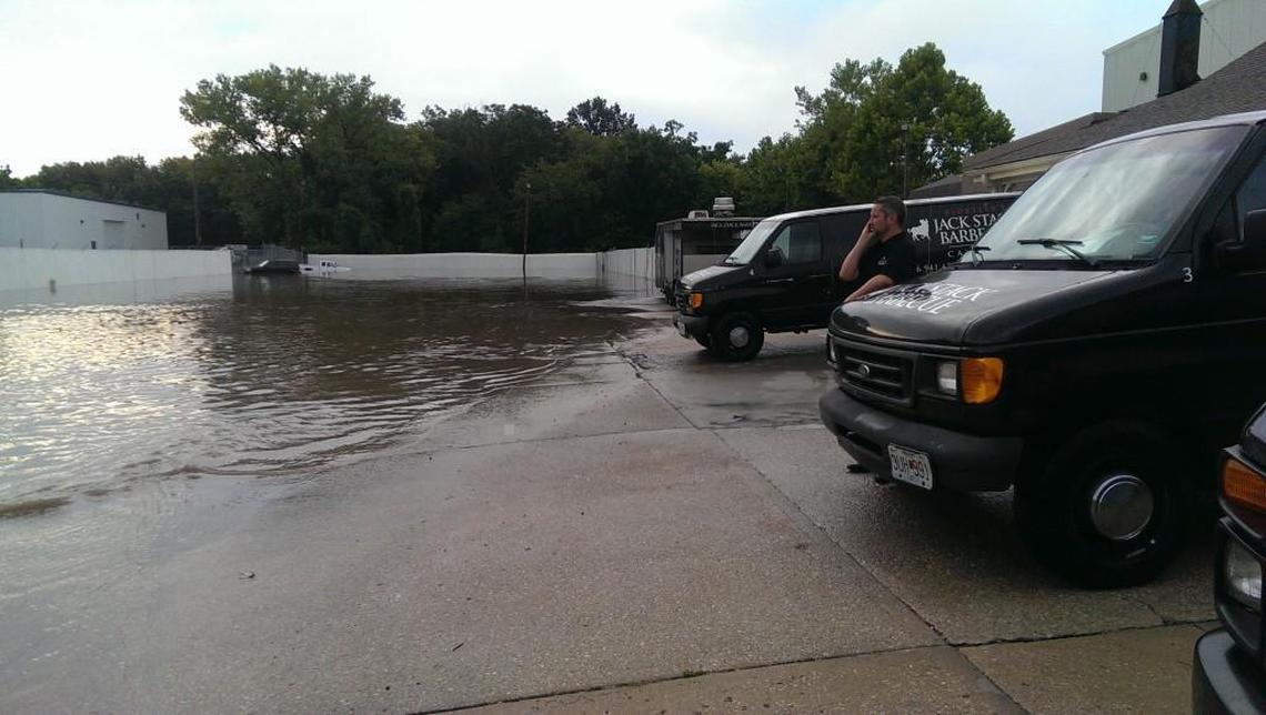 Chris Hayes, general manager of Jack Stack Barbecue in Martin City, watches as the company’s vehicles are moved away from floodwaters from the Blue River.